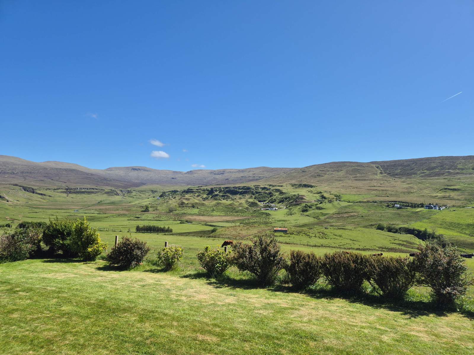 View across the fields behind Gleann Síth House, with hills beyond